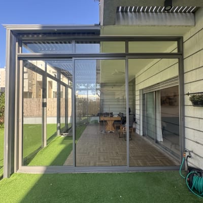 מבנה אלומיניום עם חלונות זכוכית בחצר