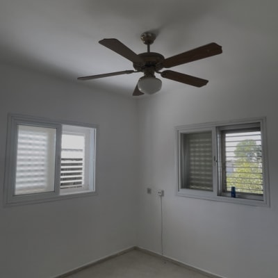 חדר ריק עם מאוורר תקרה ושתי חלונות