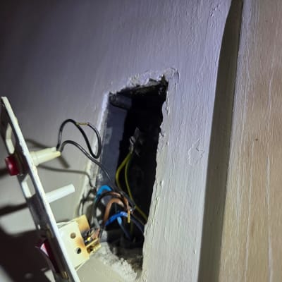 חוטי חשמל חשופים בקופסת חשמל בקיר