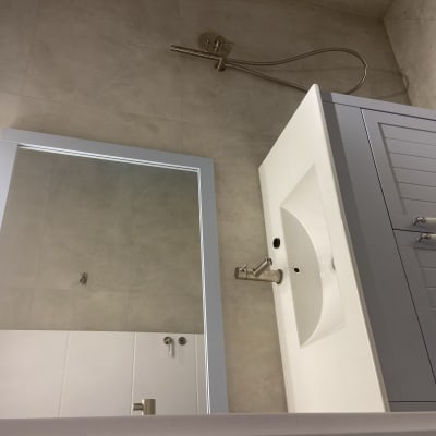 כיור חדש עם ארון אפור ומקלחת מותקנת