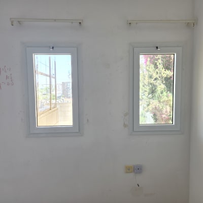 שני חלונות על קיר לבן עם נוף בחוץ