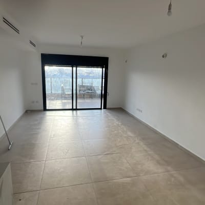 חדר ריק עם רצפת אריחים וכלי ניקוי בפינה