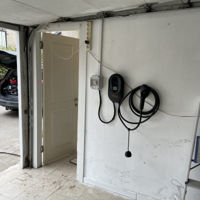 מטען לרכב חשמלי מותקן על קיר בחניה.