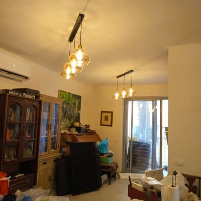 מנורות תלויות בתקרה בחדר עם רהיטים וציוד