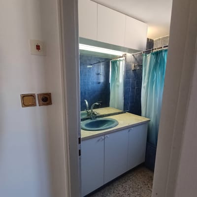 חדר אמבטיה עם כיור כחול וארון לבן