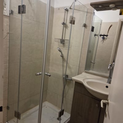 מקלחון זכוכית עם כיור בחדר אמבטיה