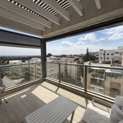 מרפסת עם סוכך נפתח ונוף עירוני