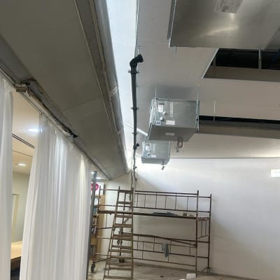 צינור שחור מותקן בתקרה עם תעלות מתכת