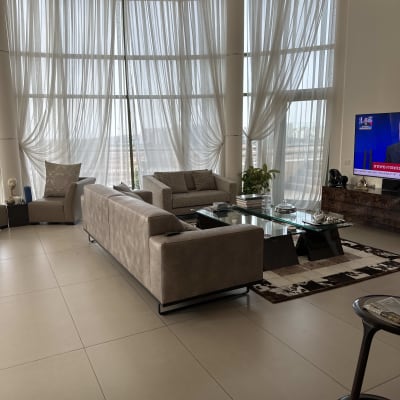 סלון עם ספה, שולחן זכוכית וטלוויזיה דולקת