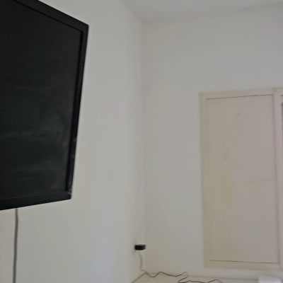 חדר עם קיר לבן, שולחן וטלוויזיה