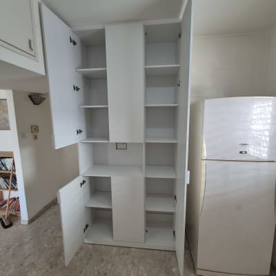 ארון פתוח עם מדפים ודלתות במטבח