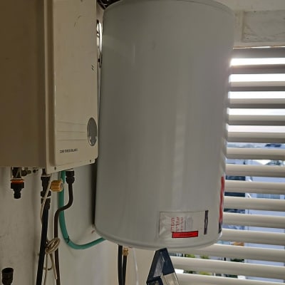 דוד שמש מותקן על קיר עם צינורות וחיבורים