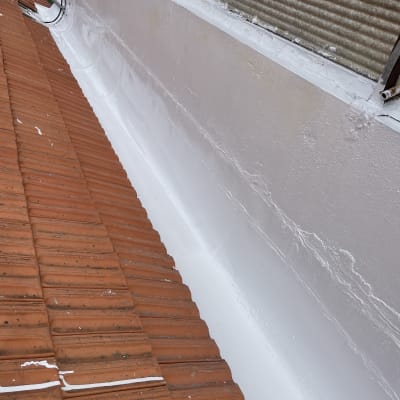 גג רעפים אדומים עם ציפוי לבן על הקיר