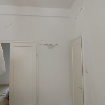 קירות עם סדקים ותיקונים נדרשים בחדר