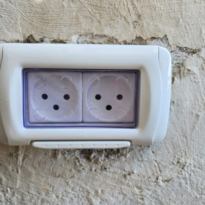 שקע חשמל כפול על קיר מחוספס