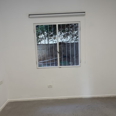 חלון עם סורגים על קיר לבן בחדר ריק