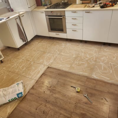 רצפת מטבח בתהליך ריצוף עם כלים וחומרים