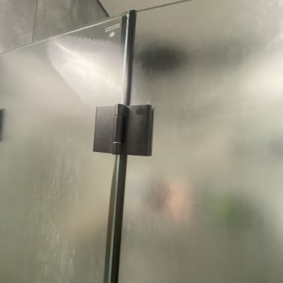 דלת זכוכית למקלחת עם ציר מתכת שחור