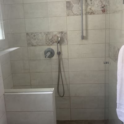 מקלחת עם ראש מקלחת, אריחים ודלת זכוכית