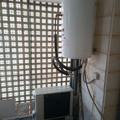 דוד שמש מותקן על קיר עם צינורות מחוברים