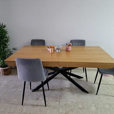 שולחן עץ עם כיסאות אפורים, עציץ ירוק ליד הקיר