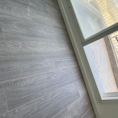 רצפת עץ ליד חלון זכוכית עם מטאטא קטן