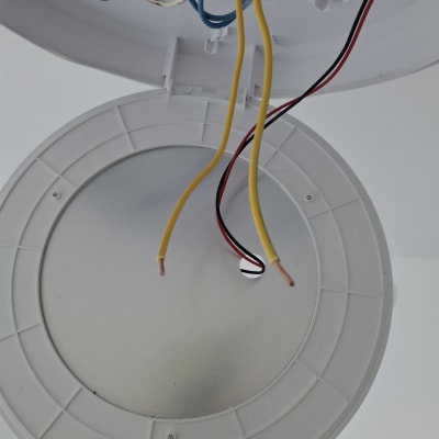 חוטי חשמל צבעוניים בתוך גוף תאורה עגול