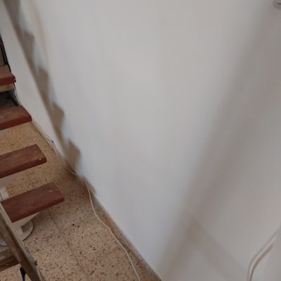 סולם ליד קיר צבוע עם כבלים על הרצפה