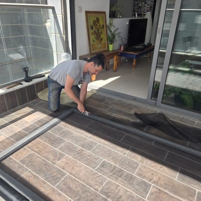 אדם מתקין מסגרת אלומיניום עם רשת על הרצפה