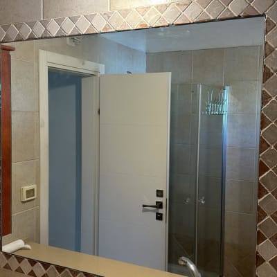 מראה גדולה עם מסגרת אריחים בחדר אמבטיה