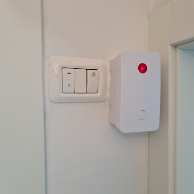 מתג חשמל ולידו מכשיר עם נורית אדומה