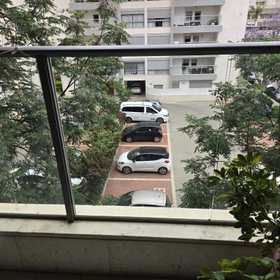 מעקה זכוכית במרפסת עם נוף לחניה