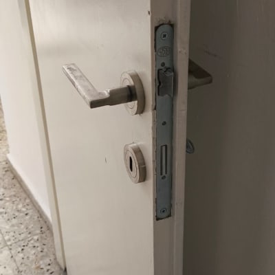 ידית ומנעול חבוי מותקנים בדלת פנים לבנה