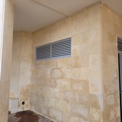 קיר אבן עם פתחי אוורור מתכתיים