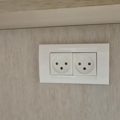 שקע חשמל כפול מותקן על קיר עץ