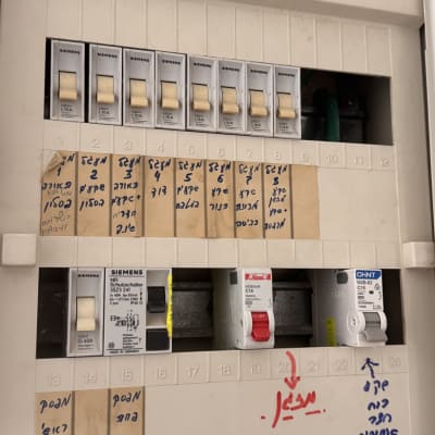 לוח חשמל עם מפסקים ותוויות בעברית