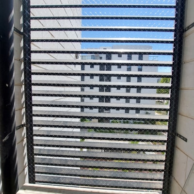 רשת מתכת מותקנת על חלון למניעת כניסת יונים