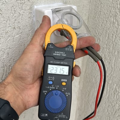 מד מתח מחובר לשקע חשמל על קיר חיצוני