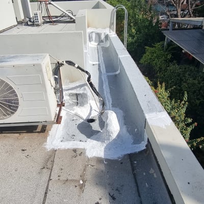 איטום גג עם חומר לבן סביב צינורות ומזגן