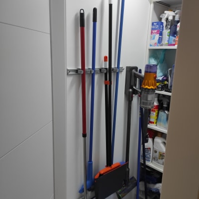 מגוון מטאטאים ומגב תלויים על הקיר