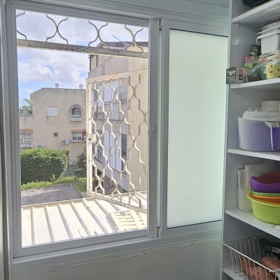 חלון אלומיניום עם סורגים ומדפים בצד