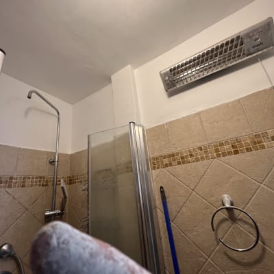 חדר אמבטיה עם מקלחת, אריחים ותנור חימום