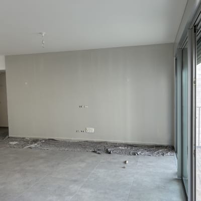 קיר צבוע בלבן עם סולם וציוד צביעה