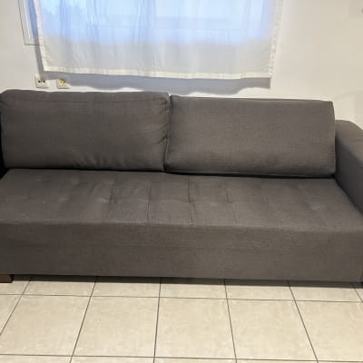 ספה אפורה עם ריפוד מרופד על רצפת אריחים