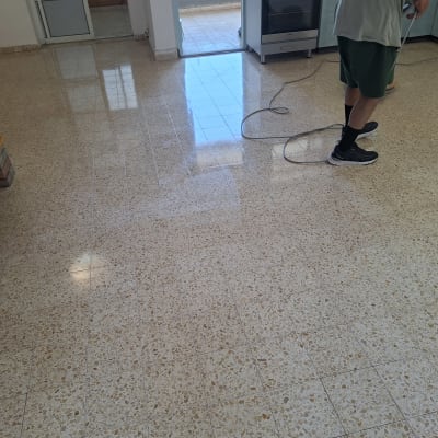 רצפה נקייה עם אדם מחזיק מכונת פוליש