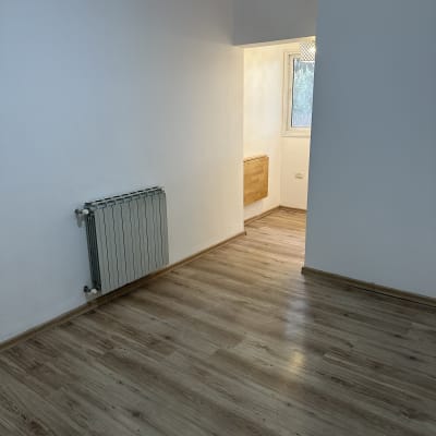 קיר צבוע בלבן בחדר ריק עם רצפת עץ