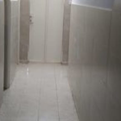 מסדרון עם קירות מרוצפים ודלת בסוף