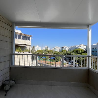 פרגולה מאלומיניום עם גג לבן ומעקה מתכת