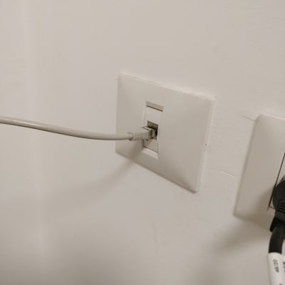 כבל רשת מחובר לשקע בקיר לבן