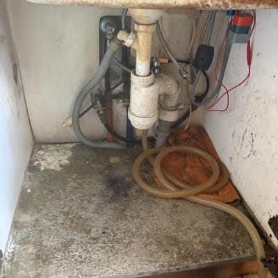 כיור עם צנרת וכלים מתחת לכיור